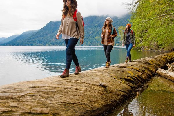 Three women walking alongside a lake