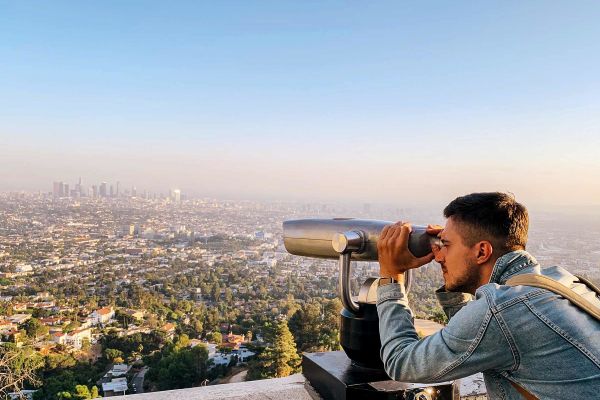 Man overlooking LA city with binoculars