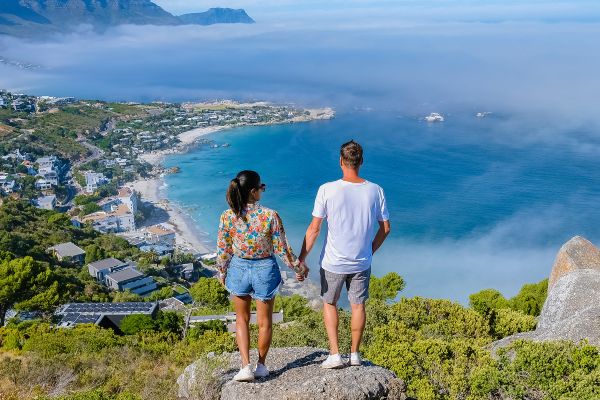 Two people standing on rock looking at ocean lookout