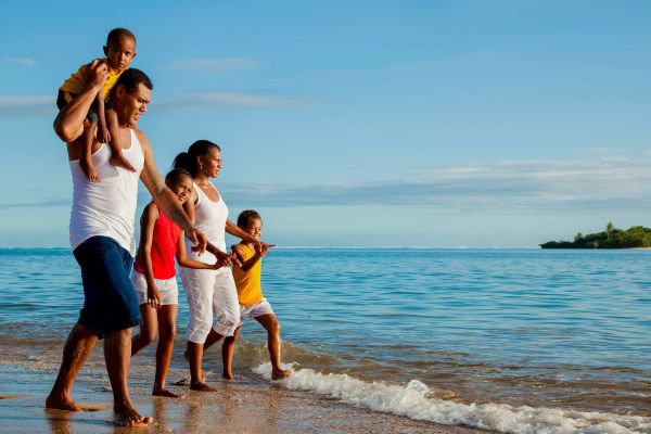 Family of 5 walking along beach in Fiji