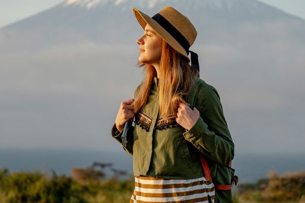 Backpacker posing in front of a mountain in the savannah