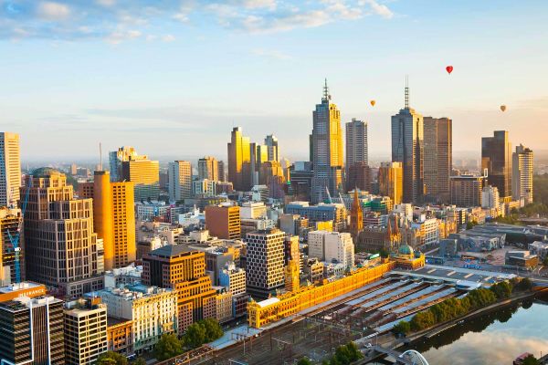 Drone shot of Melbourne city with hot air balloons afar