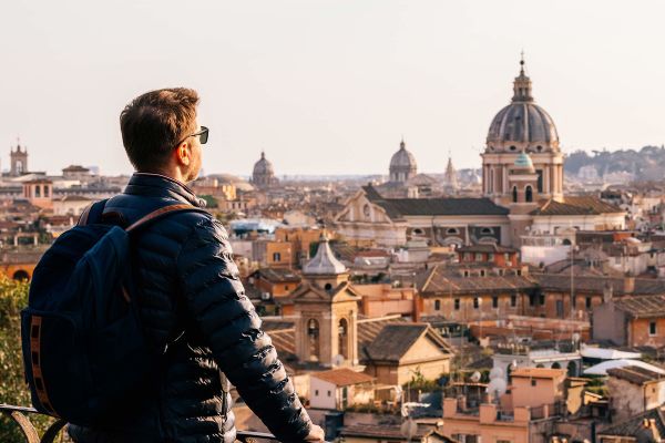 Man looking out at the city of Rome from a balcony