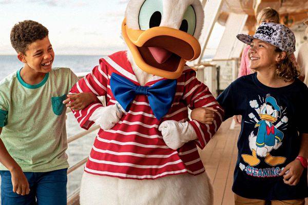 Two young boys linking arms with donald duck
