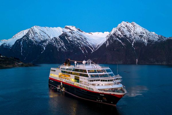 Cruise ship with snow-capped mountain in background