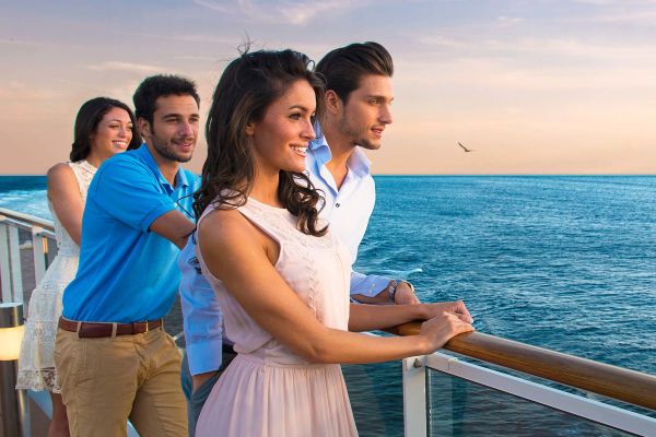 Two couples looking over cruise balcony