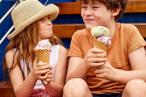 Two kids sitting on staircase eating icecream