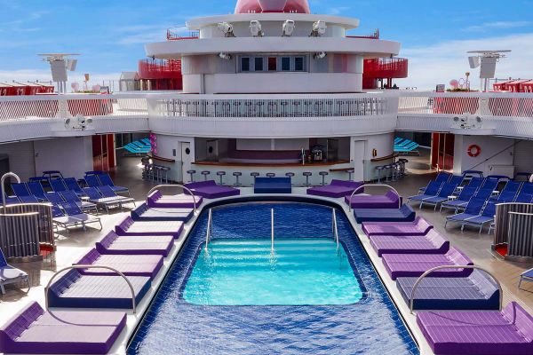 Pool on a cruise ship surrounded by purple pool chairs