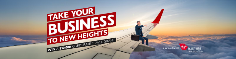 Take your business to new heights | win a $30,000* corporate travel grant. Businessman sitting on the wing of a plane