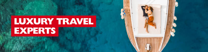 Luxury Travel Experts - couple cuddling on the bow of a luxury ship