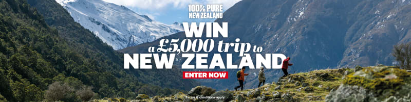 Three people hiking over rocky mountains featuring a chance to win a £5,000 trip to New Zealand