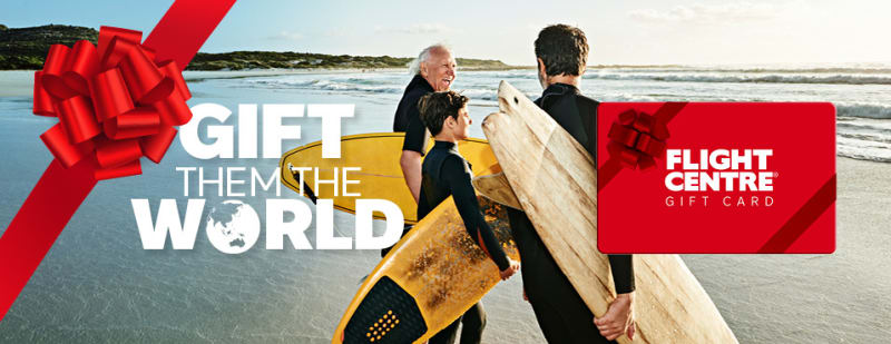 Gift them the world - flight centre. Grandfather, father and son on a beach ready to go surfing