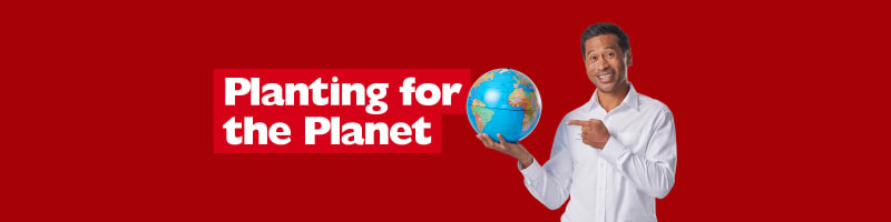 Planting for the planet - man smiling pointing to a globe