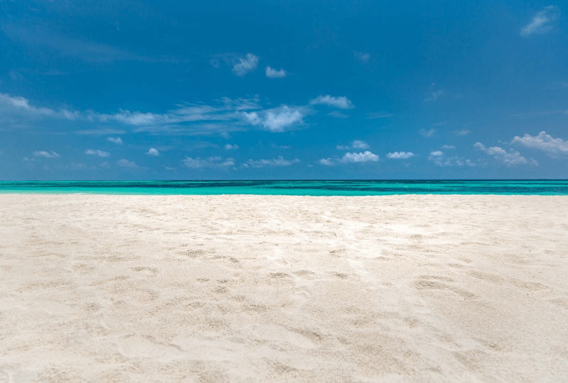 An empty white-sandy beach and blue sky