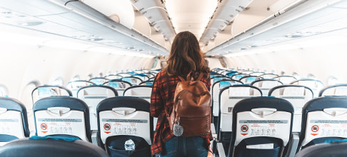 Lady walking inside of an airplane